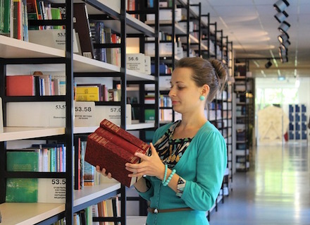 Picture of Woman with books  in a library.
